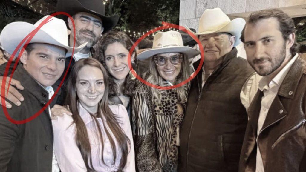 Group of seven adults posing together at an evening outdoor event; two individuals wearing white cowboy hats are circled in red.