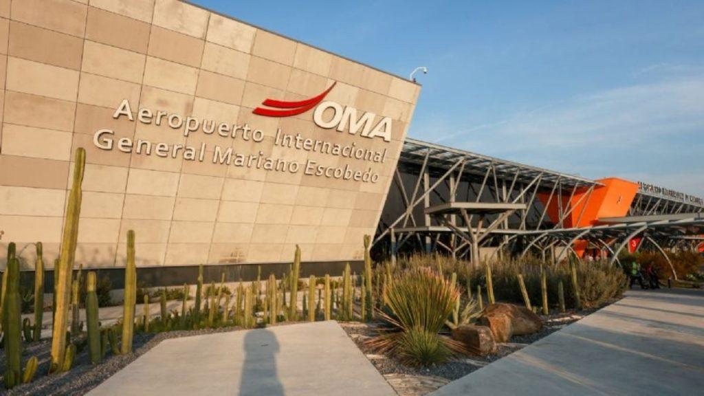 se-va-la-luz-en-el-aeropuerto-de-nuevo-leon - Minuto Cero Exterior of General Mariano Escobedo International Airport (OMA) with cactus landscaping in front of a beige wall and modern glass entrance.